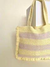 Bolso tipo tote tejido a crochet con hilo de algodón color marrón y crudo, con diseño a rayas horizontales y volados en los bordes.