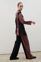 Pantalón de corte recto y tiro alto, confeccionado en algodón con diseño bicolor que combina paneles laterales en negro y panel central en beige, unidos por costuras visibles a contratono.