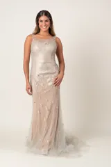 Vestido largo de fiesta color nude, con escote redondo con transparencia, espalda en V y bordados florales en hilo dorado.