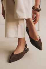 Chatita tipo slingback de gamuza color marrón, con punta fina y cierre de hebilla metálica ajustable en el talón.