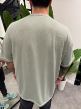 Remera verde claro de punto con cuello redondo y corte holgado.