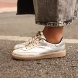 Championes de cuero metalizado color plata, con suela de goma color suela y cordones al tono.