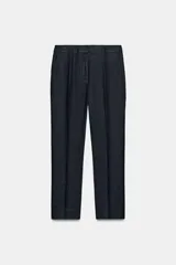 Pantalón de tiro medio confeccionado en mezcla de lino, con diseño de corte recto, bolsillos laterales y cierre frontal con cremallera y ganchos metálicos.