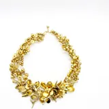 Collar corto dorado con cuentas y apliques de flores y hojas.