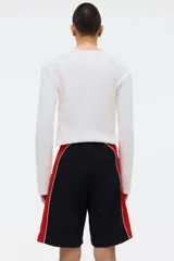 Short de ripstop negro con corte holgado, cintura elástica con cordón de ajuste y franjas laterales rojas con ribete blanco.