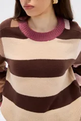 Sweater de tejido de punto con diseño de rayas horizontales en tonos marrones, beige y rosa. Presenta cuello redondo, corte holgado y mangas largas con puños en contraste.