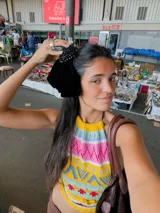 Top tejido a mano con diseño de cuello halter, confeccionado en hilo con un patrón geométrico multicolor que incluye tonos amarillos, rosas, celestes y blancos.