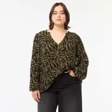 Blusa de manga larga con estampado abstracto en tonos verde y negro, escote en V y corte holgado.