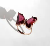 Anillo de acero con baño de oro rosa de 18k, con dije grande de mariposa de cristal color borgoña.