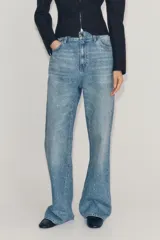 Jeans wide leg de tiro medio confeccionado en denim con efecto lavado, corte relaxed y diseño de pernera ancha. Cuenta con cinco bolsillos, trabillas en la cintura y cierre frontal con cremallera y botón metálico. Presenta aplicación de brillos en toda la prenda.