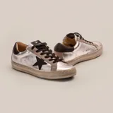 Zapatillas plateadas de cuero vacuno con aplique de estrella en cuero vegetal negro, cordones negros y suela de caucho. El detalle de gamuza es de color gris.