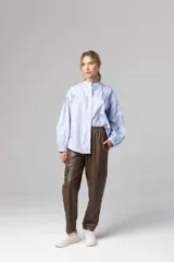 Pantalón babucha gris de cuero sintético con cintura elastizada y bolsillos laterales con solapa.