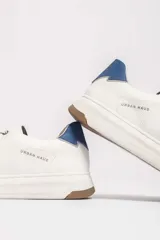 Zapatillas urbanas blancas con detalle azul en el talón y suela de goma.