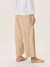Pantalon de corte ancho y holgado, confeccionado en una mezcla de algodón, viscosa y lino. Presenta un diseño de tiro medio con bolsillos traseros y costuras visibles que recorren el largo de las piernas.