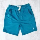 Short deportivo azul petróleo con cintura elástica ajustable con cordón y bolsillos laterales.