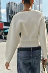 Jersey de punto rib color blanco, con cuello barco y mangas largas con sisas anchas.