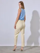Pantalón de vestir color crema con finas rayas verticales en amarillo pálido. Tiene bolsillos simulados en la parte delantera y corte recto.