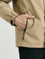 Campera 2 en 1 color beige, con cuerpo y capucha desmontable, manga larga, cierre frontal con botones a presión y bolsillos laterales engomados.