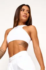 Top deportivo de cuello alto, confeccionado en tejido de poliamida y elastano. Presenta un diseño minimalista, ajuste al cuerpo y forro interno para mayor soporte.