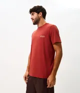 Remera deportiva de poliamida con tecnología dry, color terracota, de corte regular, cuello redondo y manga corta. Presenta estampa lettering pequeña en el pecho.