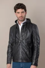 Campera de cuero negro con capucha gris desmontable, cierre frontal, bolsillos con cierre y detalles de hebillas en el cuello y la cintura.