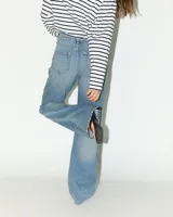 Jeans de tiro medio con corte recto desde la cadera hasta el bajo, de color celeste claro. Diseño clásico de cinco bolsillos con cierre de cremallera y botón metálico.