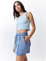 Minifalda color beige con elástico en la cintura, cordones ajustables y costuras marcadas en los laterales.