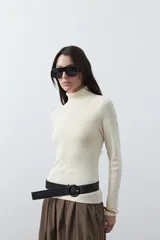 Polera de manga larga y cuello alto, confeccionada en tejido de punto fino, con un ajuste ceñido al cuerpo.