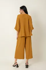 Conjunto de dos piezas compuesto por una blusa de manga corta con cierre frontal de botones y un pantalón ancho de corte holgado con cintura elástica.