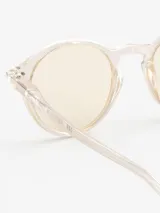 Lentes de sol Izipizi modelo #SUN D, de forma redonda, con montura transparente y cristales amarillos.