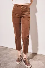 Pantalón de pana color beige, tiro medio, corte recto y largo al tobillo.