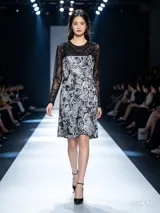 Vestido corto de encaje con mangas largas transparentes y cuerpo con estampado floral en contraste blanco y negro.