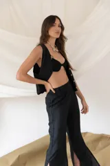 Chaleco de lino en color beige, con escote en V, cierre frontal con botones y bolsillos delanteros decorativos.