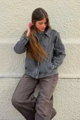 Cazadora de denim en tono gris lavado, con diseño de costuras marcadas, cuello camisero, cierre frontal con botones y bolsillos laterales.