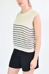 Musculosa de tejido de punto con diseño a rayas horizontales oscuras sobre base color crema, cuello redondo y corte recto.