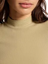 Blusa de cuello alto y manga corta, confeccionada en tela acanalada de ajuste entallado.