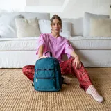 Mochila rosa de tafeta con apertura superior con cierre y tiradores metálicos, bolsillos internos, bolsillo con doble cierre metálico al frente, asas rígidas de mano y correas regulables para colgar en la espalda.