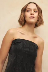 Top strapless negro con diseño tipo corset, de textil engomado y texturizado.