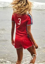 Short deportivo rojo con ribetes blancos, de tiro medio, con bolsillos frontales y bolsillo trasero.