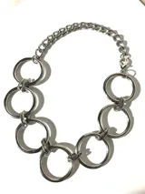 Gargantilla plateada con cadena de eslabones y aros grandes.