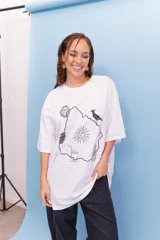 Remeron de algodón blanco con estampa central en negro que representa el mapa de Uruguay con diversos símbolos nacionales como el sol, el escudo, un mate y el hornero.