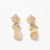 Caravanas colgantes compuestas por una pieza superior cuadrada con textura rugosa en tono dorado, un elemento central de resina traslúcida en color verde oliva y una pieza inferior de resina con efecto marmolado en tonos beige y crema.