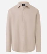 Camisa beige de tricolina texturizada, corte amplio, manga larga y abotonada al frente.