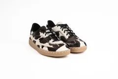 Championes de estilo urbano con diseño combinado en cuero negro y paneles laterales con estampado animal print tipo leopardo. Presenta detalle en color dorado en el talón, cierre con cordones negros y suela de goma en tono natural.