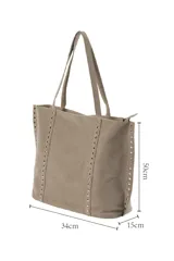 Bolso tipo shopper de gamuza en color gris, con detalles de tachuelas plateadas en los laterales. Cuenta con cierre superior y asas largas para llevar al hombro.