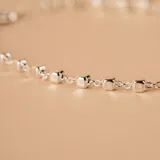 Pulsera de cadena fina de plata 925 con pequeños dijes en forma de cubos pulidos distribuidos a lo largo de la misma.