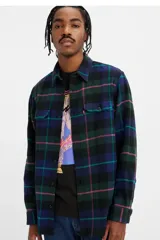 Camisa a cuadros azul, verde y violeta, de corte recto, manga larga y dos bolsillos frontales con botón.