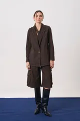 Blazer de silueta recta confeccionado en denim, con solapa clásica, cierre frontal con un botón y bolsillos delanteros.