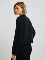 Buzo negro de algodón con cuello redondo y corte holgado.