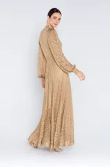 Vestido largo color dorado con textura bordada, escote en V, mangas largas abullonadas y corte en la cintura.